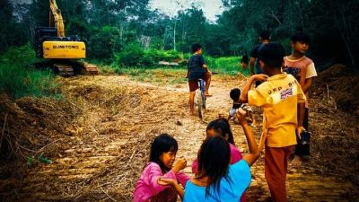 Senyum anak-anak yang asik bermain ditengah kegiatan pembukaan akses jalan desa Ampar Bedang