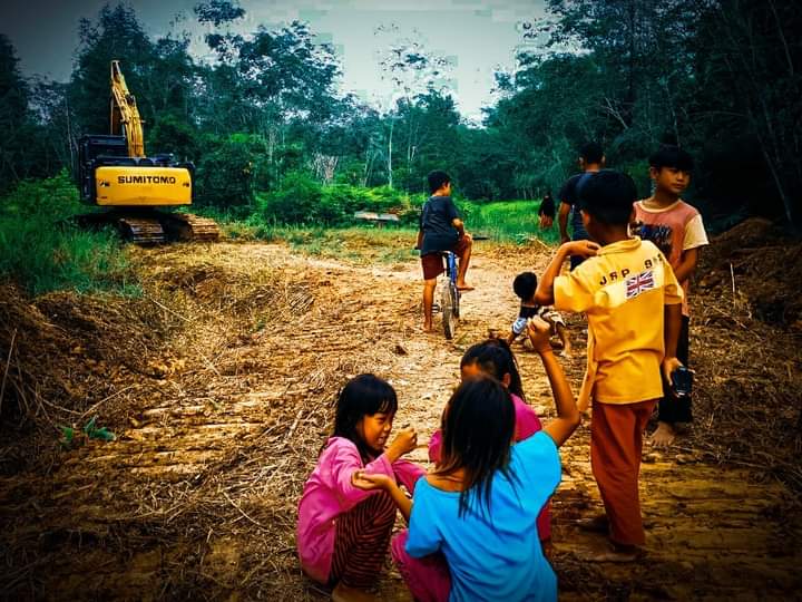 Senyum anak-anak yang asik bermain ditengah kegiatan pembukaan akses jalan desa Ampar Bedang